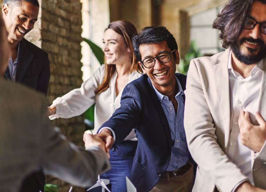 business people smiling and shaking hands at a meeting